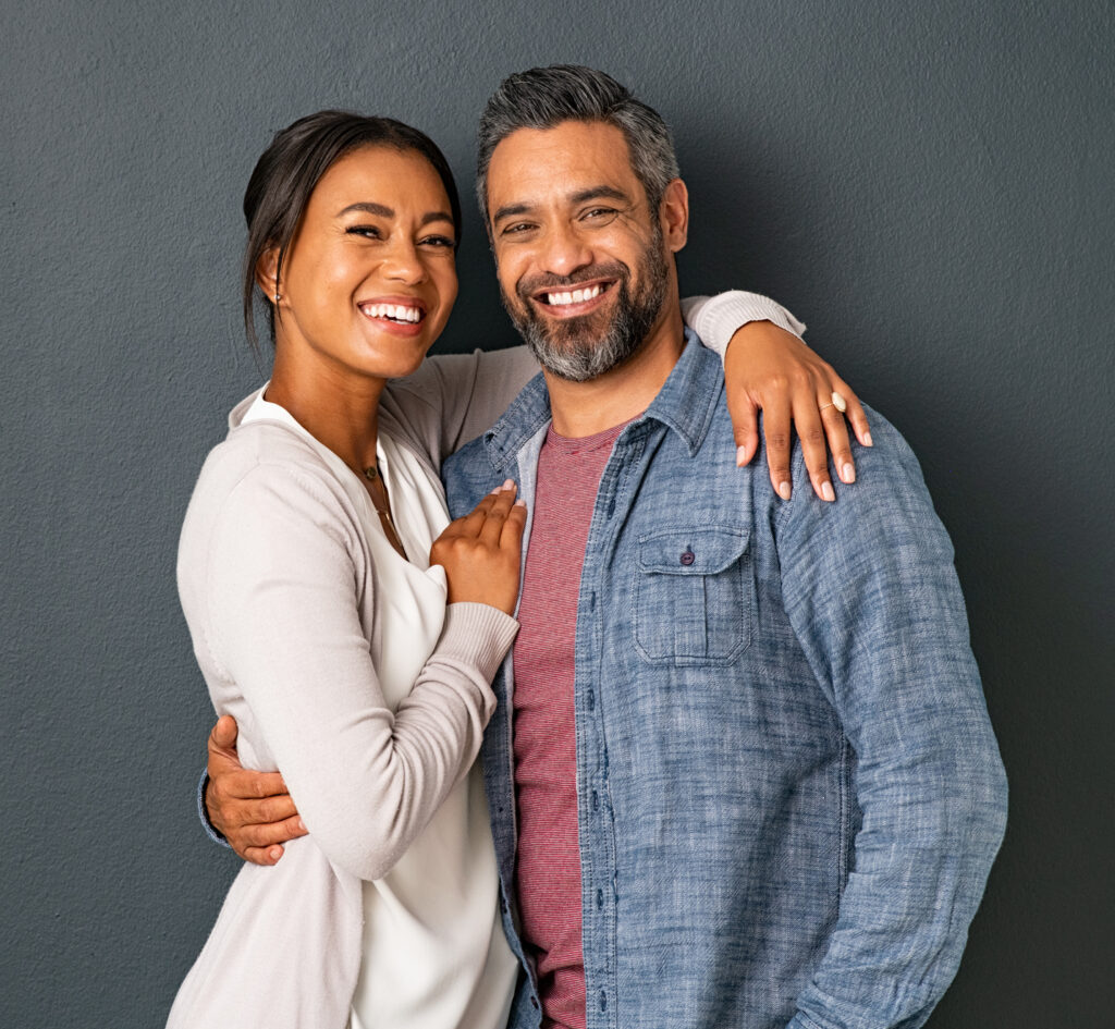 Portrait of happy mid adult couple embracing and looking at camera