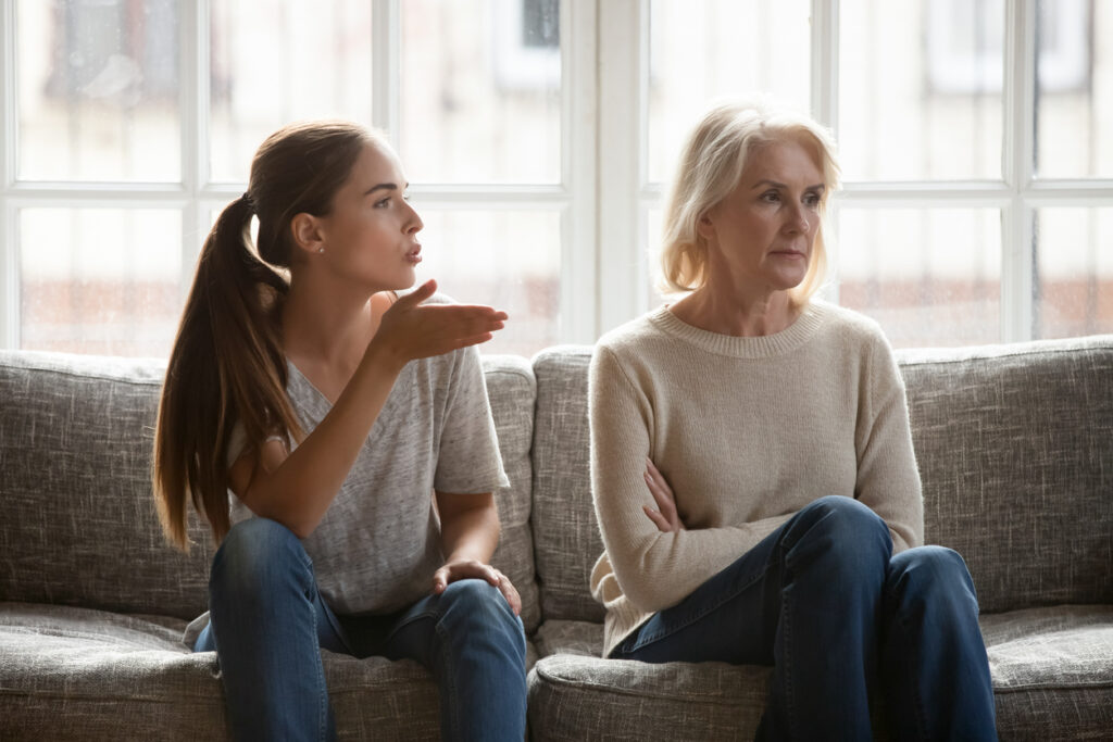 Adult daughter and older mother sitting together, representing mixed emotions Mother’s Day can bring.