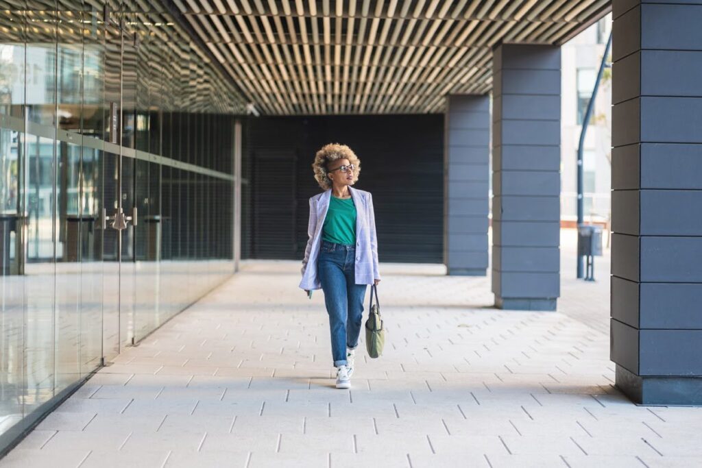 Professional woman walking through a modern corridor, representing the mental load and emotional labor many women carry