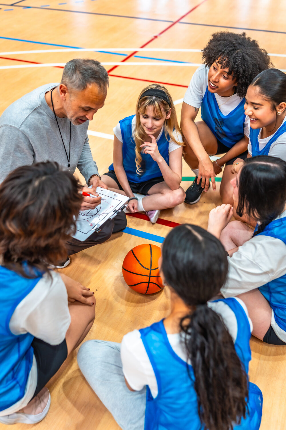 Basketball coach and his girl's high school team running plays