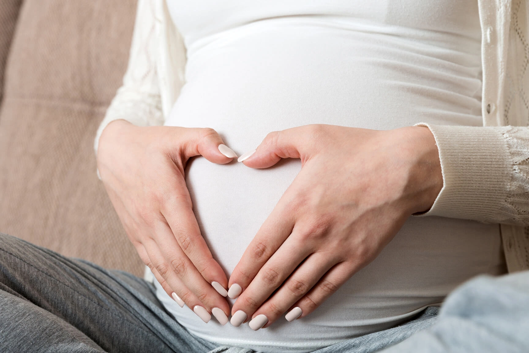 Pregnant Lady with hands on belly in a heart position