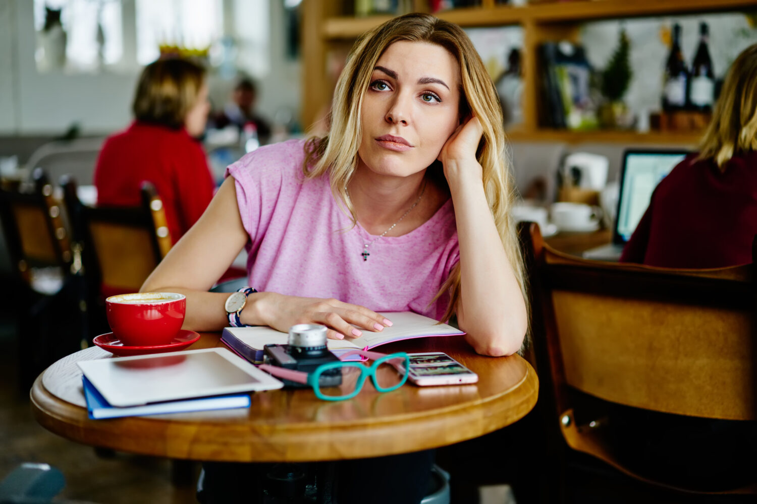 Tired, distracted woman at a cafe.