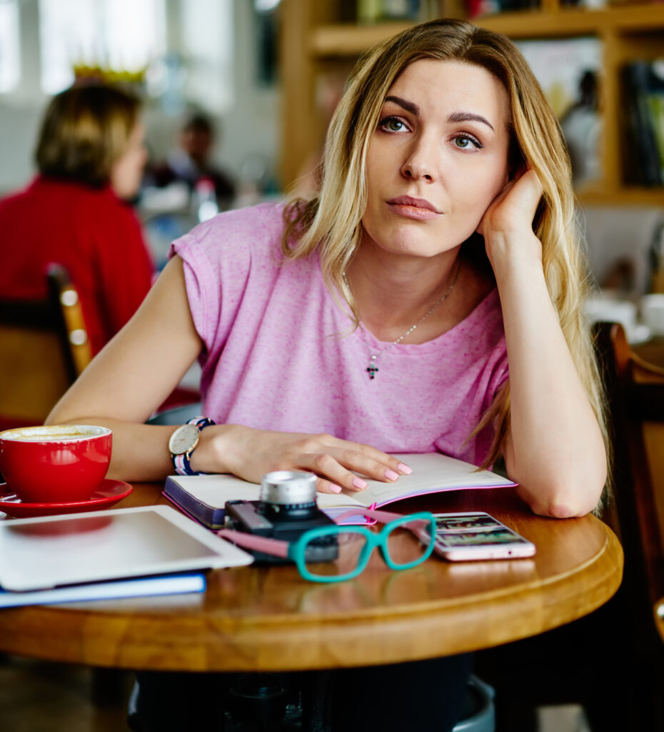 Tired, distracted woman at a cafe.